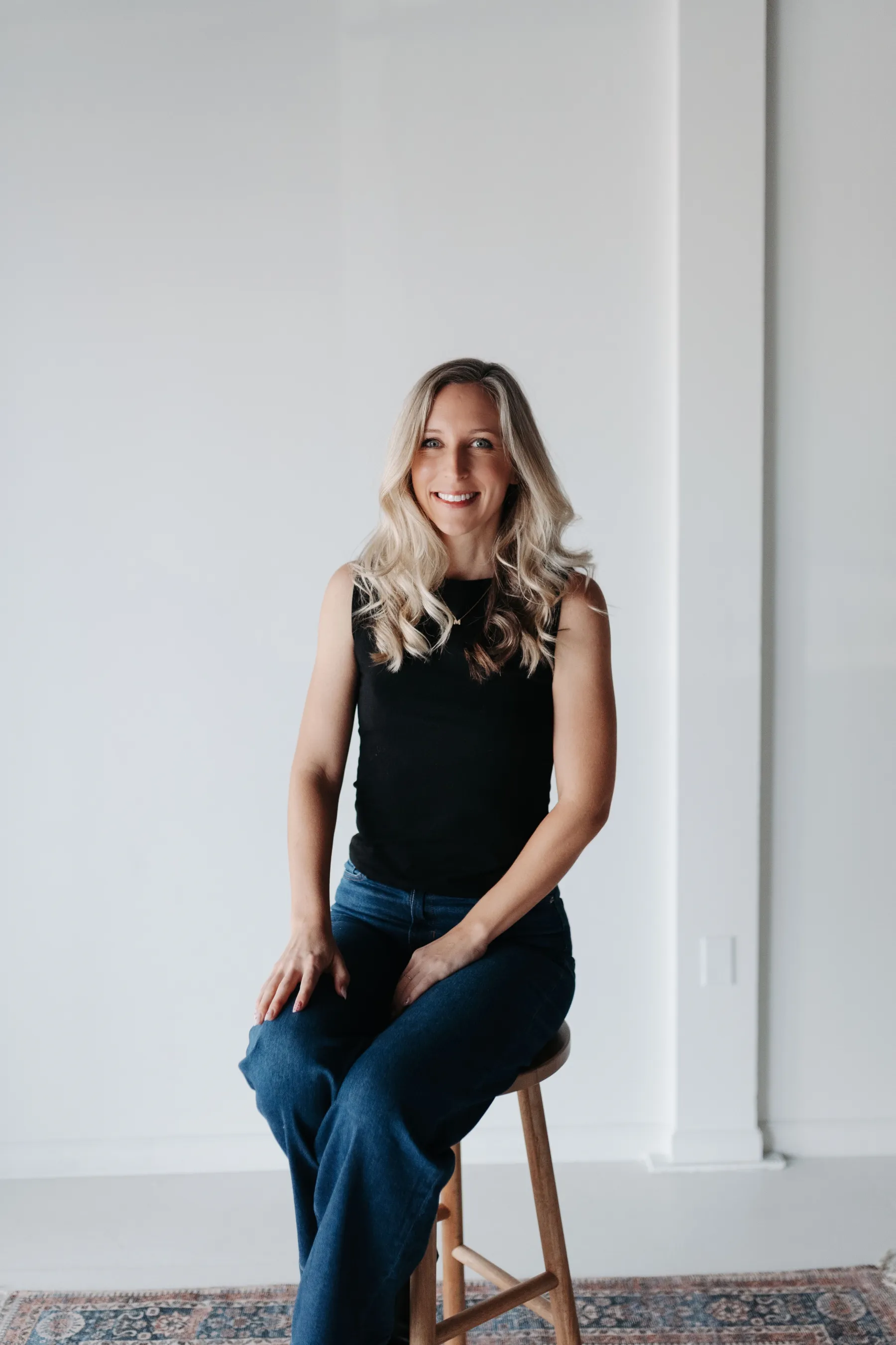 Therapist seated on a stool in a bright studio